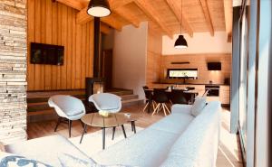 a living room with a couch and chairs and a table at Chalet Slovensky Raj in Smižany