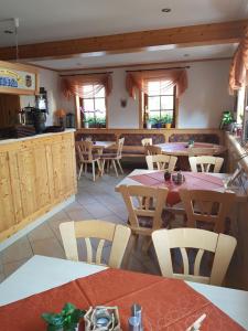 Fraenkischer Hof في Zeitlofs: غرفة طعام مع طاولات وكراسي في مطعم