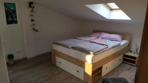 ein kleines Schlafzimmer mit einem Bett und einem Dachfenster in der Unterkunft Ferienwohnung "Burgblick" in Heldrungen