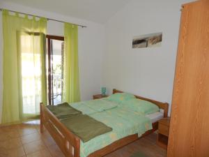 ein Schlafzimmer mit einem Bett mit grüner Bettwäsche und einem Fenster in der Unterkunft Apartmani Nin in Nin