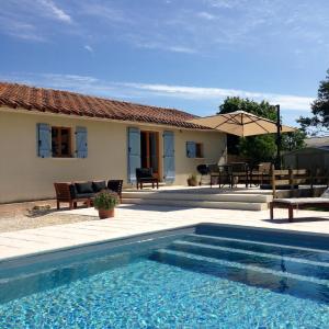 a house with a swimming pool in front of a house at LE TEXIER The Cottage in Verteillac