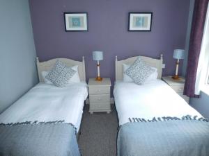two beds in a bedroom with purple walls at Anam Cara B&B in Cork