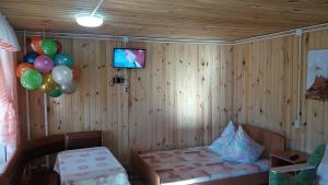 マンジェロクにあるApartments on river Katun`のベッド、テレビ、風船が備わる客室です。