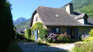 a stone house with flowers in front of it at Maison La Luzienne - Lou Astiou in Luz-Saint-Sauveur