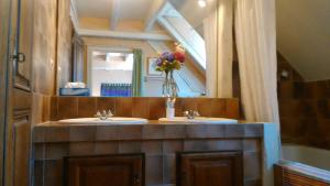 a bathroom with two sinks and a vase of flowers at Maison La Luzienne - Lou Astiou in Luz-Saint-Sauveur +49 photos