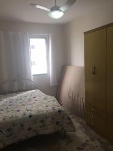 a bedroom with a bed and a dresser and a window at Praia Grande Frente ao Mar-Albatroz in Praia Grande