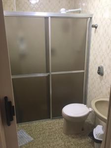 a bathroom with a shower with a toilet and a sink at Praia Grande Frente ao Mar-Albatroz in Praia Grande