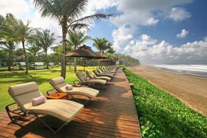 eine Reihe von Stühlen und Sonnenschirmen an einem Strand in der Unterkunft The Samaya Seminyak Bali in Seminyak