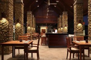 ein Restaurant mit Holztischen und einem Koch in der Küche in der Unterkunft The Samaya Seminyak Bali in Seminyak