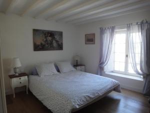 een slaapkamer met een bed en een raam bij Couleurs et jardin in Saint-Augustin