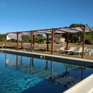 a swimming pool with chairs and a pavilion at Agriturismo il Casalino in Pari