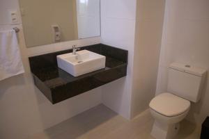 a bathroom with a sink and a toilet at Hotel Marrocos in Pelotas