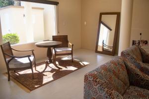a living room with a couch and a table and a mirror at Hotel Marrocos in Pelotas