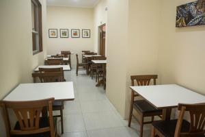 a row of tables and chairs in a restaurant at Hotel Marrocos in Pelotas