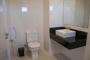 a bathroom with a white toilet and a sink at Hotel Marrocos in Pelotas