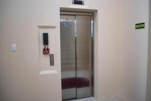 a elevator in a building with a sign on the wall at Hotel Marrocos in Pelotas