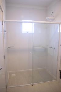 a shower with a glass door in a bathroom at Hotel Marrocos in Pelotas