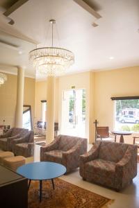 a living room with couches and a chandelier at Hotel Marrocos in Pelotas