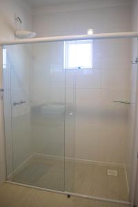 a shower with a glass door in a bathroom at Hotel Marrocos in Pelotas