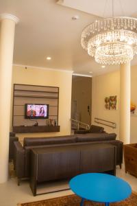 a living room with a couch and a chandelier at Hotel Marrocos in Pelotas
