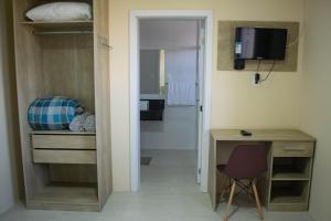 a room with a desk and a table and a chair at Hotel Marrocos in Pelotas