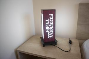 a sign sitting on top of a table at Hotel Marrocos in Pelotas