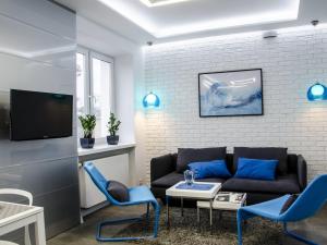 a living room with a couch and blue chairs at Apartament Skoczyńskiego 11a in Stalowa Wola