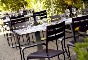 une rangée de tables avec des verres à vin dans l'établissement Kyriad Niort - La Crèche, à La Crèche