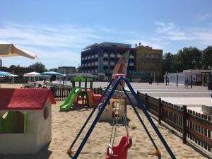 a playground with a slide in the sand at Astoria in Fano