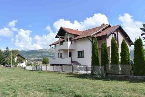 a white house with a fence and trees at Apartman Zdenka in Livno