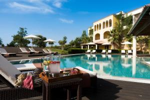 a swimming pool with a table and chairs next to a building at Cascade Wellness Resort in Lagos