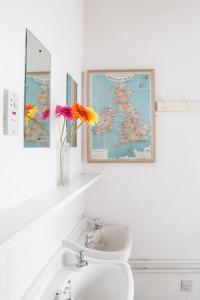 baño con lavabo y jarrón con flores en Kirkby Stephen Hostel, en Kirkby Stephen