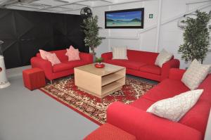 a living room with red couches and a tv at surrey b&b in Surrey Estate