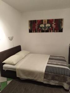 ein Schlafzimmer mit einem Bett mit einer weißen Tagesdecke in der Unterkunft Split studio Irisha in Split