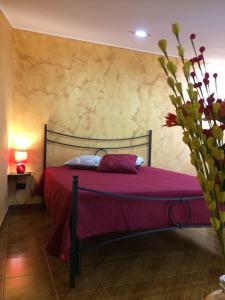 1 dormitorio con 1 cama con edredón rojo en Marielle Maison, en Santo Stefano di Camastra