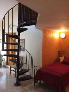 Una escalera de caracol en una habitación junto a una cama en Marielle Maison, en Santo Stefano di Camastra