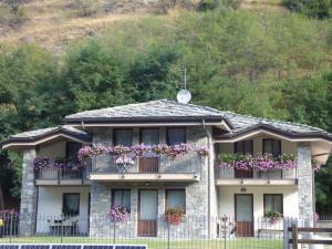 ein Haus mit einem Balkon mit Blumen darauf in der Unterkunft La Tana del Ghiro in Villefranche