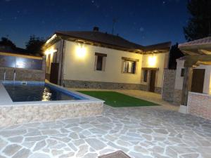 a house with a swimming pool at night at Casa Armonia in Ávila