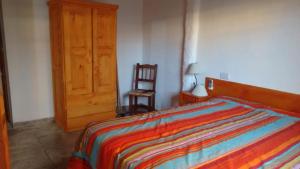 1 dormitorio con 1 cama y puerta de madera en El Encuentro en Juana Koslay 
