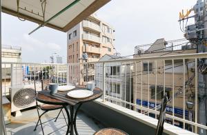 balkon ze stołem i krzesłami w budynku w obiekcie Haneda Lex House w Tokio