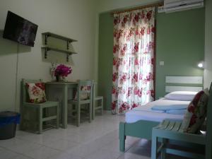 um quarto de hospital com uma cama, uma mesa e cadeiras em Ifigenia's Rooms em Kardamili