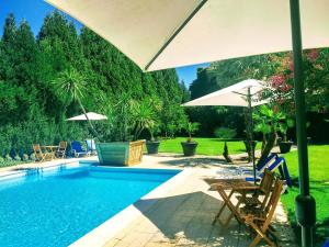 uma piscina com cadeiras e guarda-sóis em Casa Do Prado Guesthouse em Vila Real