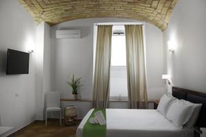 Un dormitorio con una cama grande y una ventana en Roma Resort Colosseum, en Roma