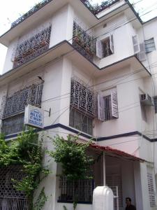 a white building with balconies and a sign on it at Blue Chip in Kolkata