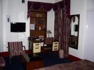 a bedroom with a desk and a bed with a computer at Blue Chip in Kolkata
