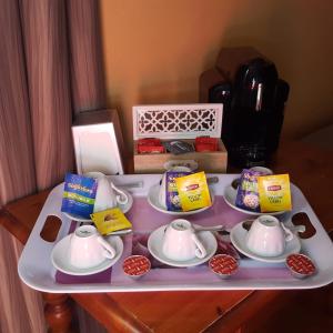 uma bandeja com bules e pacotes sobre uma mesa em Hotel Calaluna em Biella