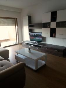 a living room with a tv and a coffee table at Terraços do Rio in Portimão