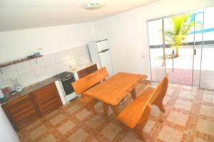 a kitchen with a wooden table and chairs in a room at Brasil-Kite in Paracuru