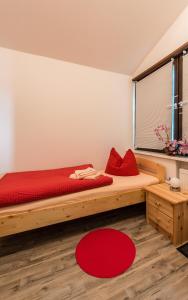 Un dormitorio con una gran cama de madera con almohadas rojas en Ferienhaus Little Rennsteig, en Eisenach
