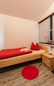 a bedroom with a large wooden bed with red pillows at Ferienhaus Little Rennsteig in Eisenach